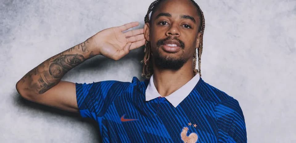 Jugador posando con camiseta de Francia y gesto de escucha