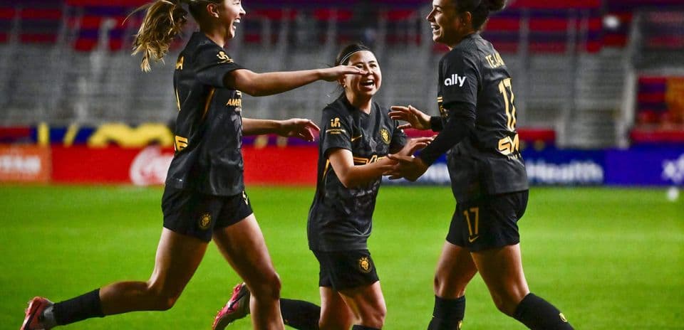 Tres jugadoras celebrando un gol en el campo
