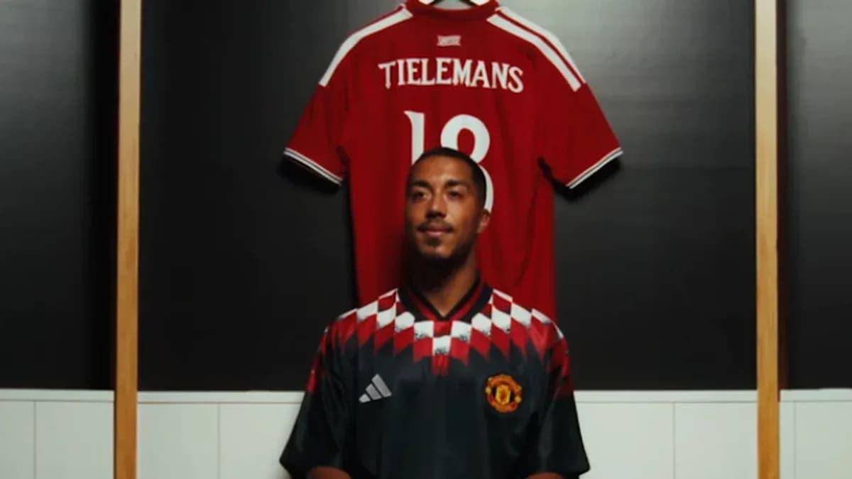 Jugador posando frente a camiseta en vestuario