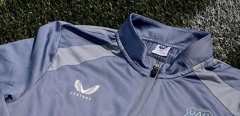 Chaqueta gris con logotipo de Everton y Castore