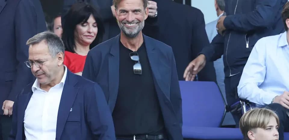 Entrenador sonriendo en evento con otros asistentes