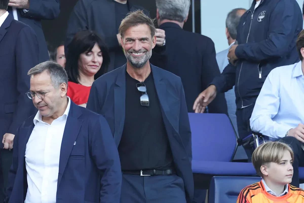 Entrenador sonriendo en evento con otros asistentes