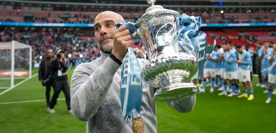 Entrenador sosteniendo trofeo en Wembley tras la victoria