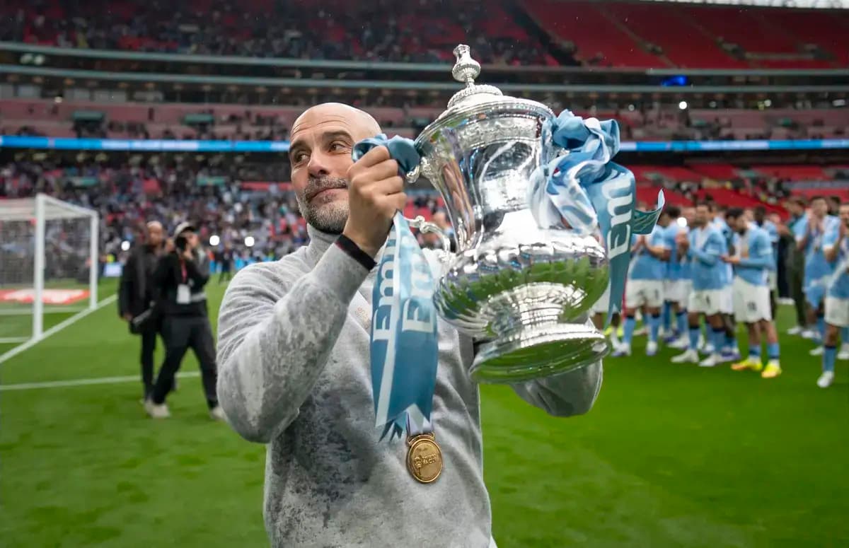 Entrenador sosteniendo trofeo en Wembley tras la victoria