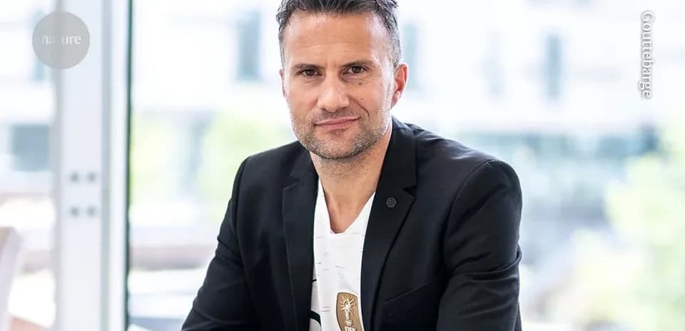 Hombre posando con chaqueta negra y camiseta blanca