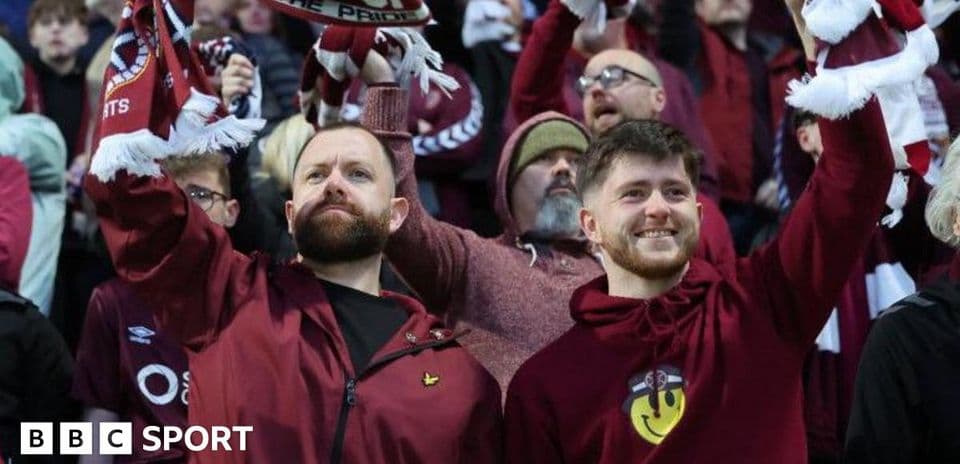 Aficionados sosteniendo bufandas en un partido