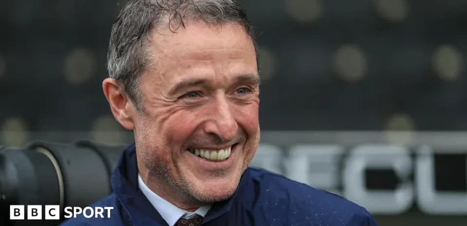 Entrenador sonriendo en el campo de fútbol