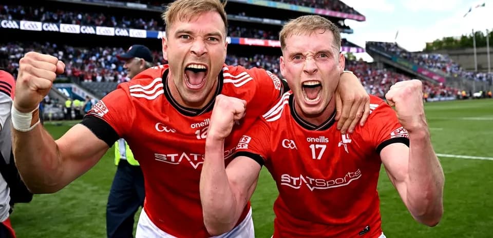 Dos jugadores celebrando con camisetas rojas en el campo