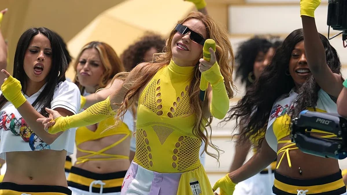 Artista actuando con bailarinas en vestimenta colorida