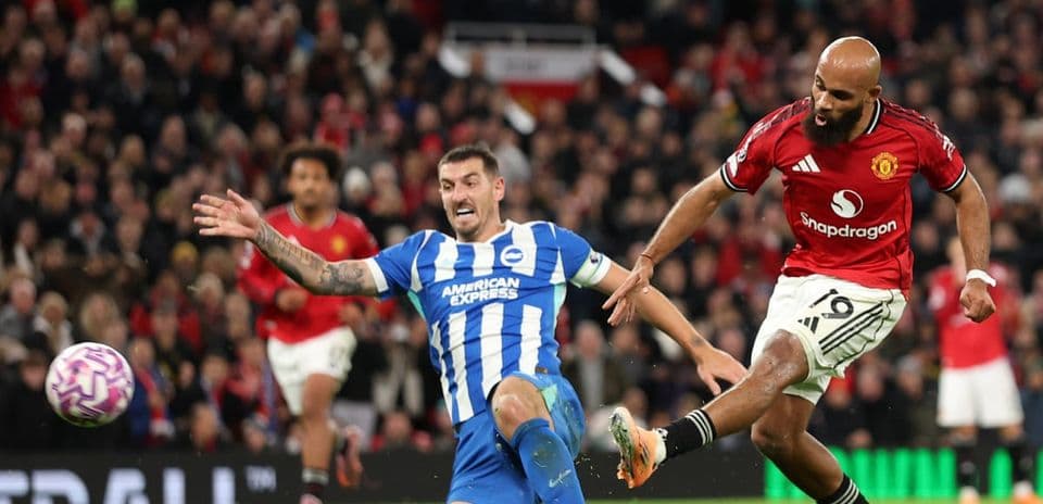 Jugador de Brighton cae mientras un jugador de Manchester United dispara