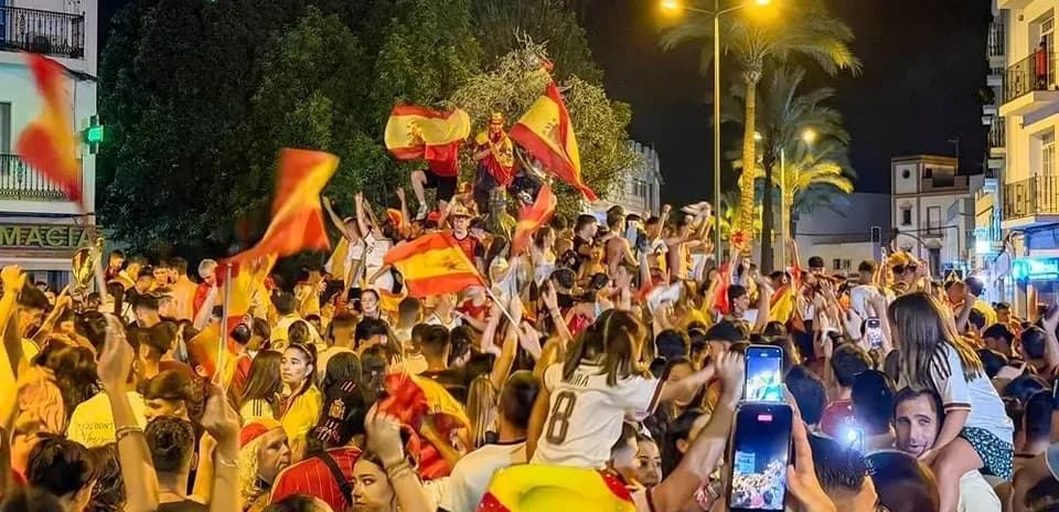 Celebración de aficionados con banderas en la calle