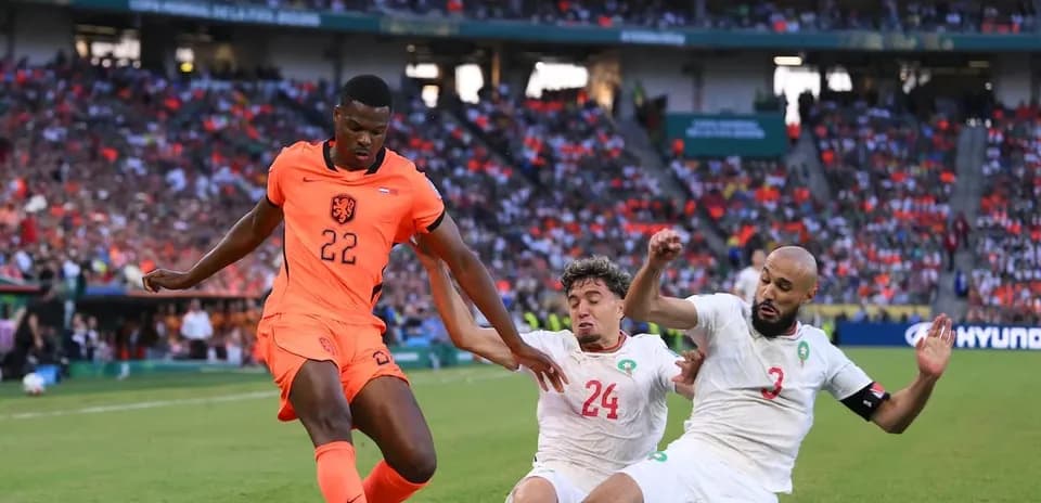 Jugador de Países Bajos esquivando a dos defensores de Marruecos