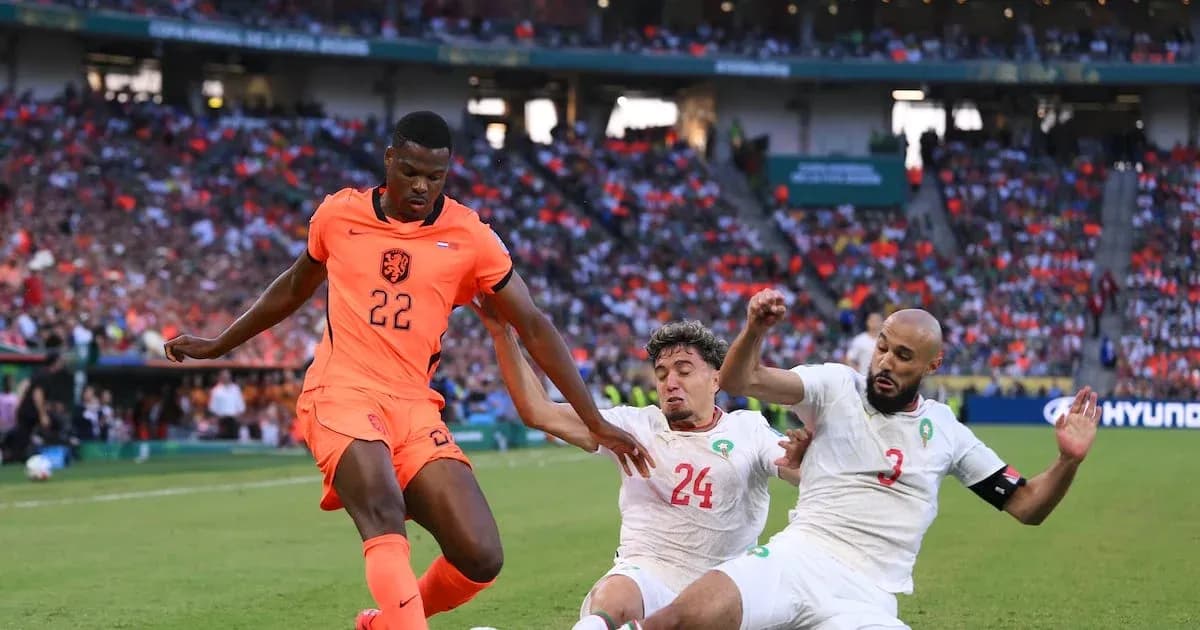 Jugador de Países Bajos esquivando a dos defensores de Marruecos