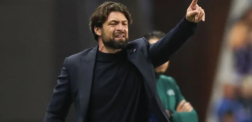 Entrenador dirigiendo al equipo desde la línea lateral