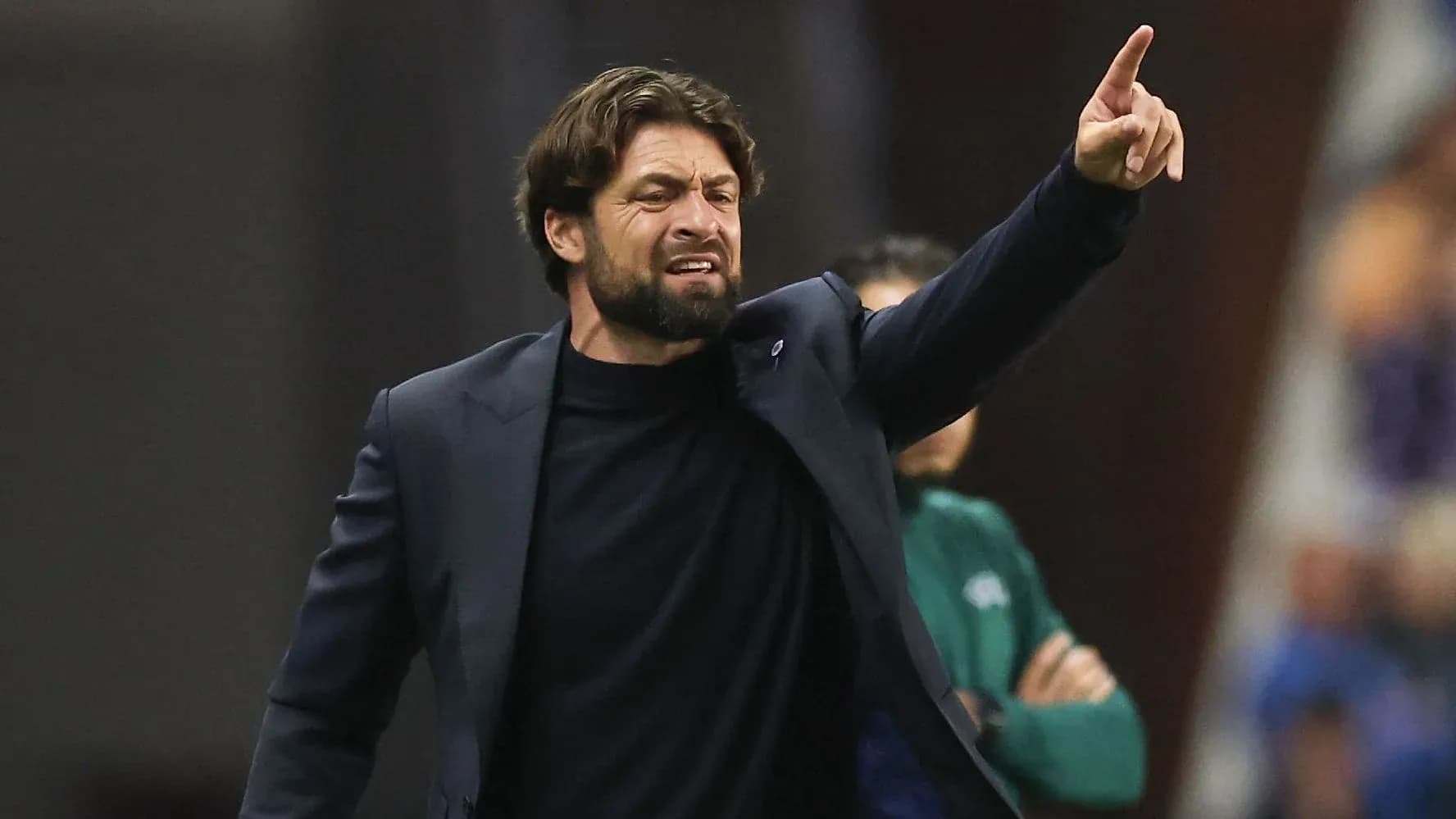 Entrenador dirigiendo al equipo desde la línea lateral