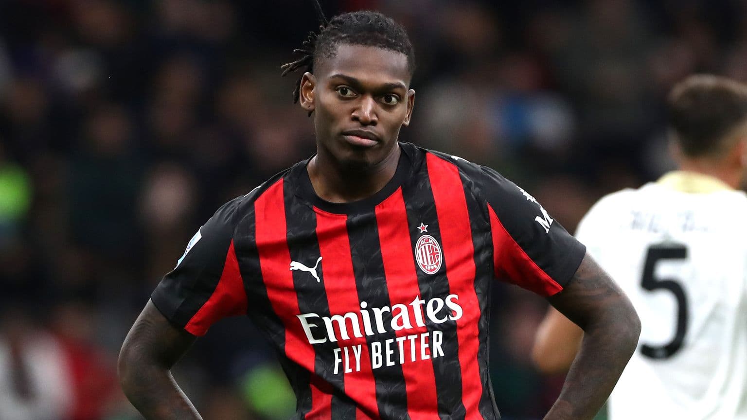 Jugador de AC Milan en uniforme de rayas rojas y negras