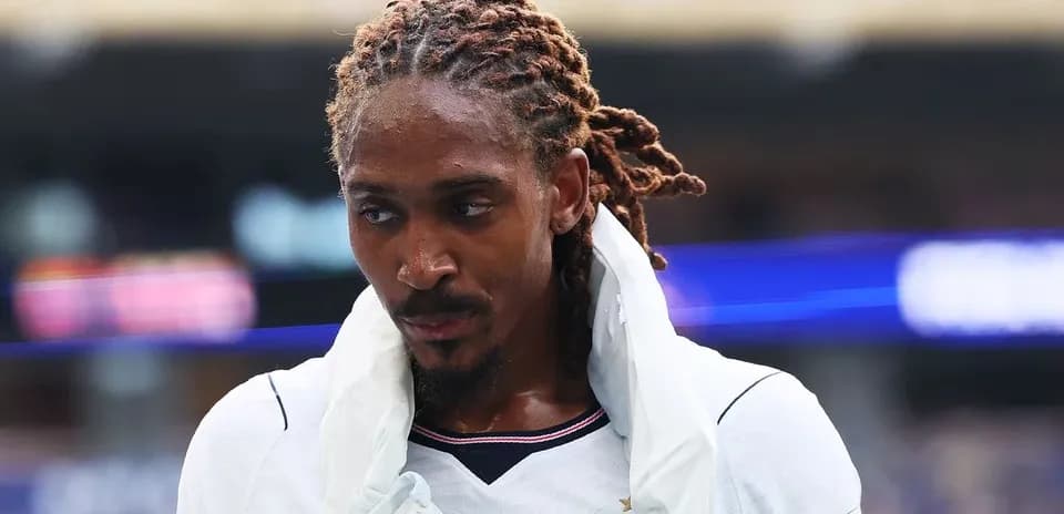 Jugador con cabello rizado saliendo del campo