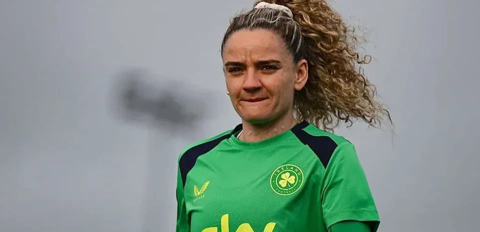 Jugadora de fútbol con uniforme verde en campo