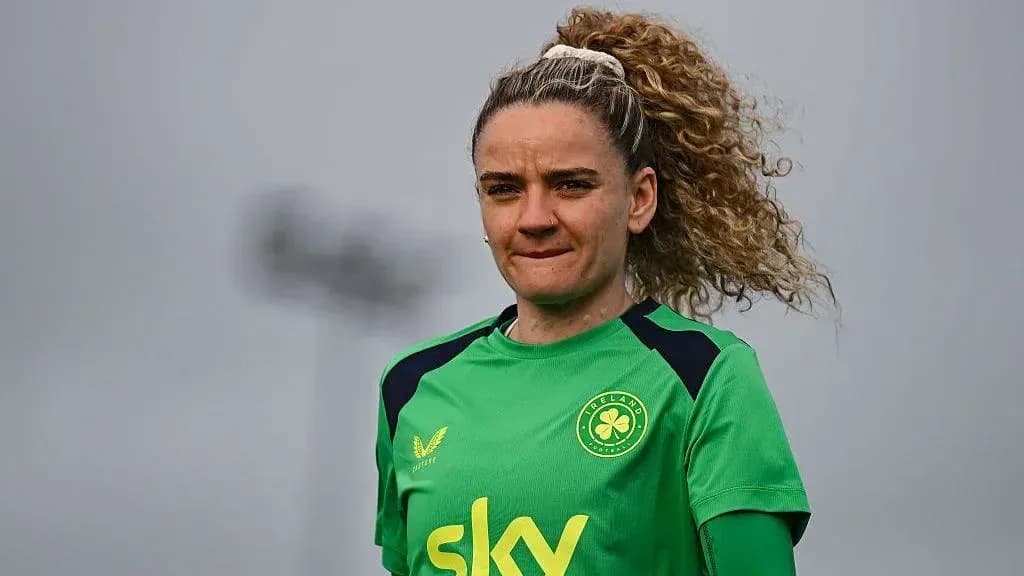 Jugadora de fútbol con uniforme verde en campo