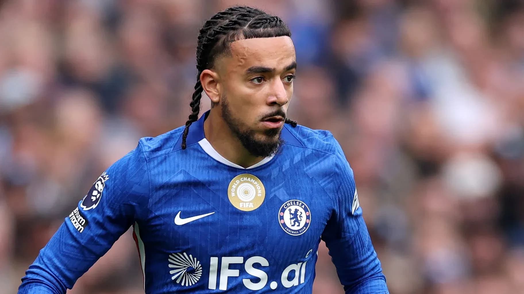 Jugador de Chelsea corriendo con el balón en el campo