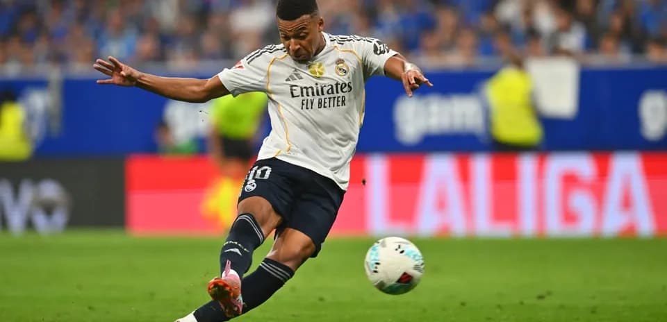 Jugador de Real Madrid disparando al balón
