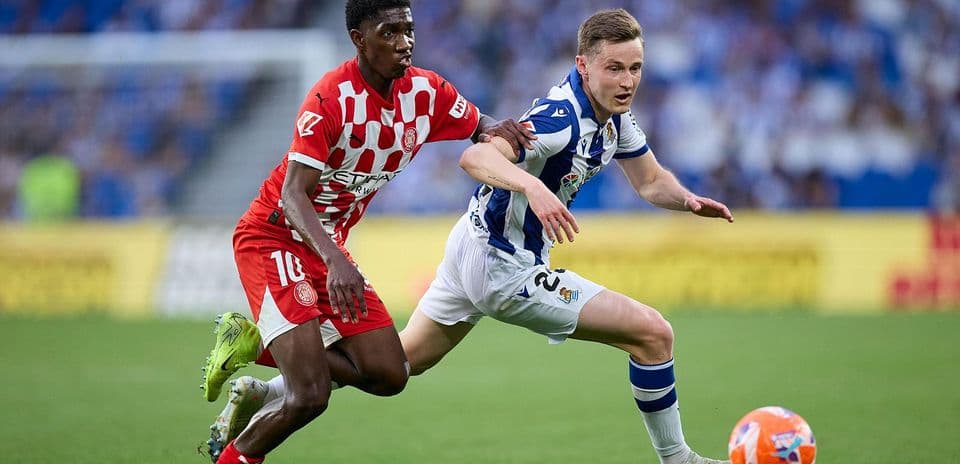 Jugador de Girona persiguiendo a jugador de Real Sociedad