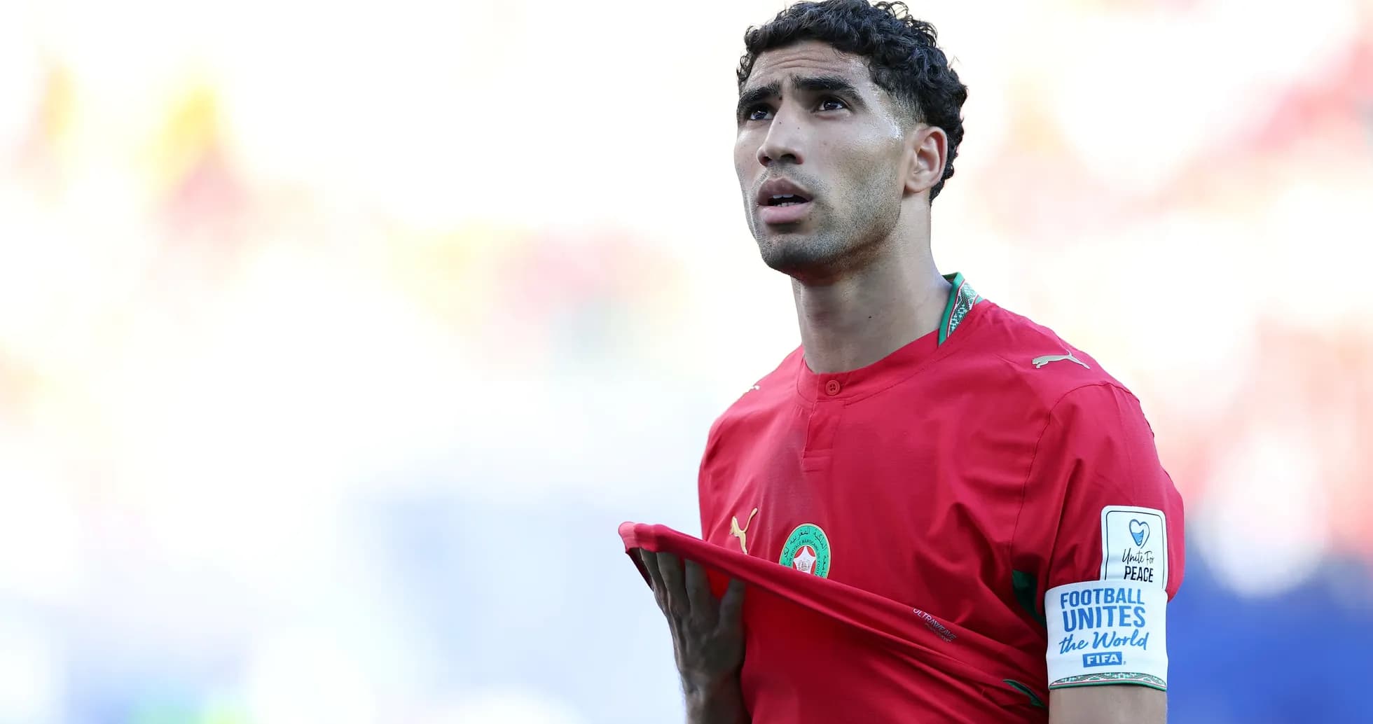 Jugador de Marruecos sosteniendo su camiseta en el campo