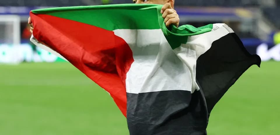 Hombre sosteniendo una bandera en el campo de juego
