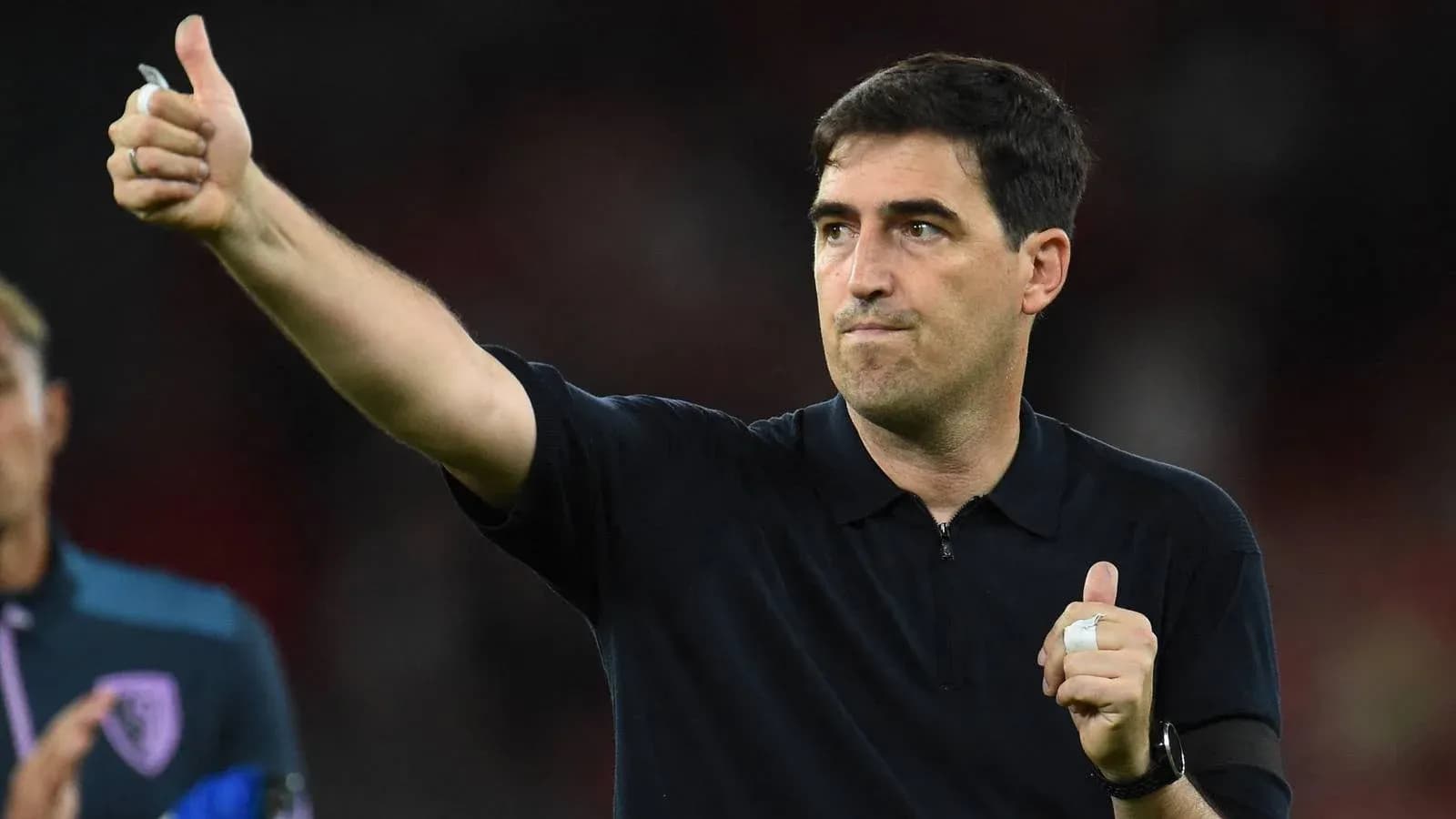Entrenador aplaudiendo y señalando con pulgar arriba