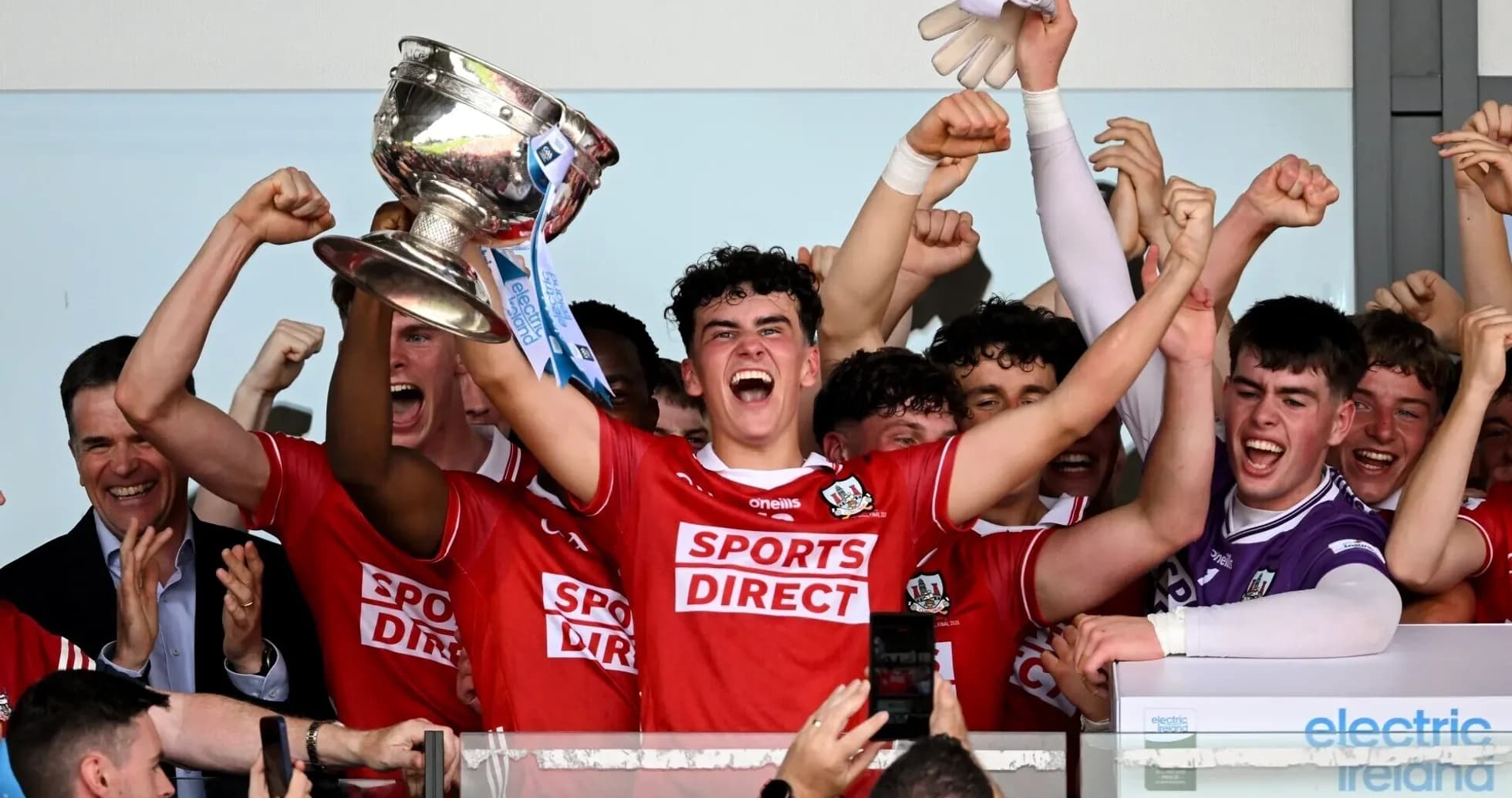 Jugadores celebrando con el trofeo en el podio
