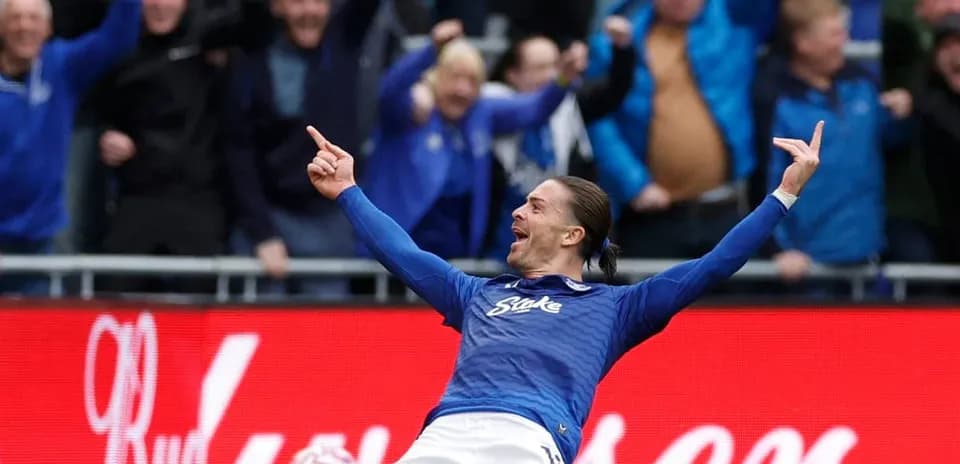 Jugador celebrando un gol con aficionados en el fondo