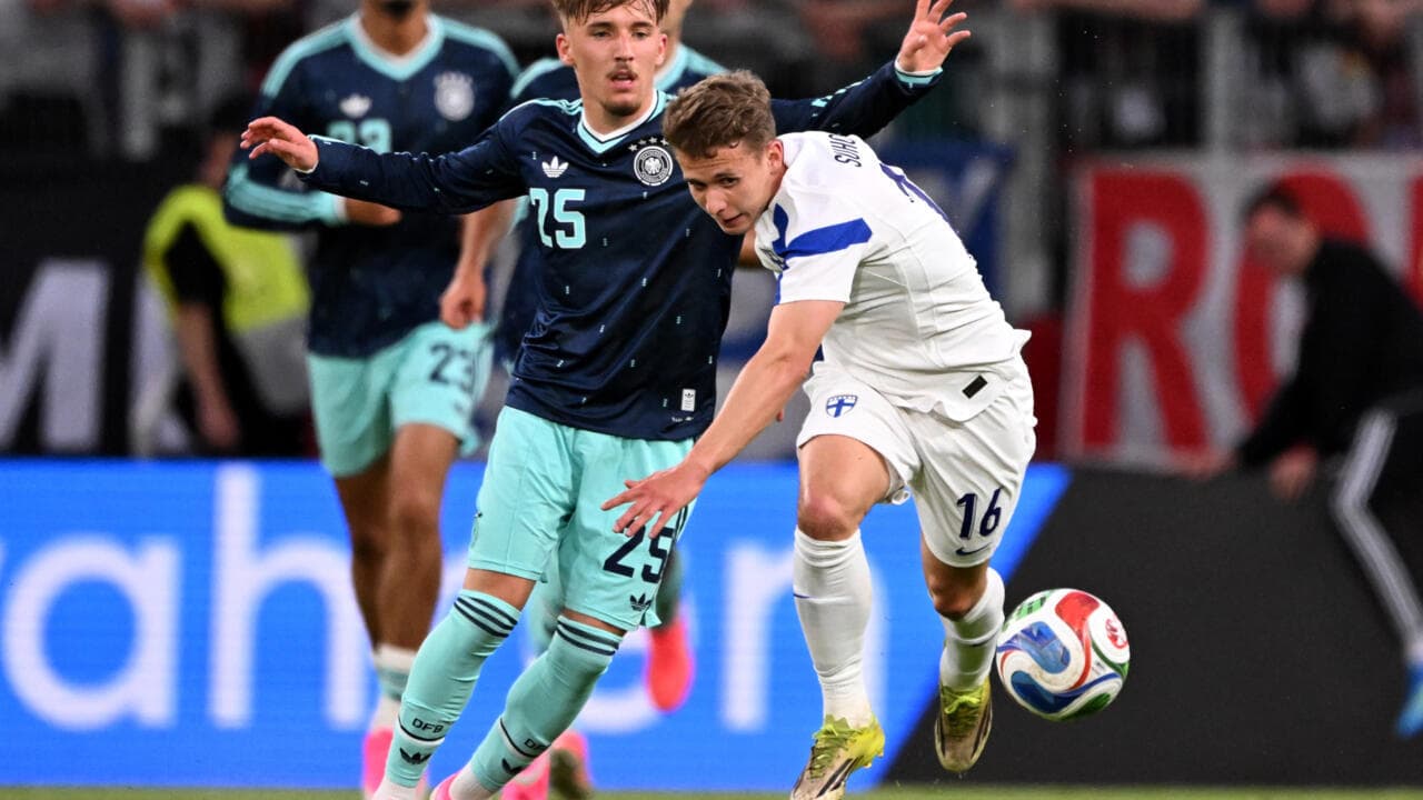 Jugador finlandés luchando por el balón contra alemán