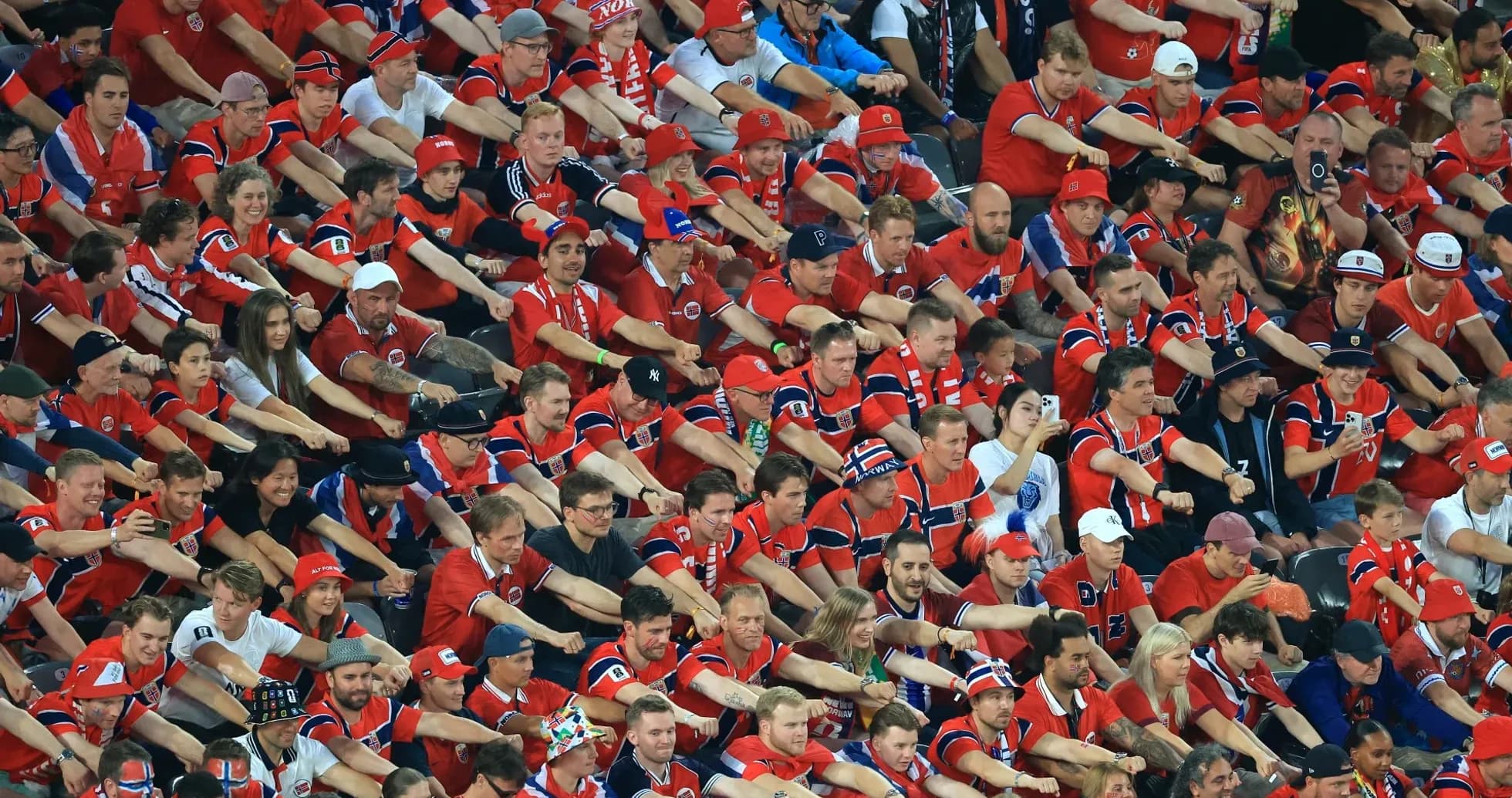 Aficionados en camiseta roja animando en el estadio
