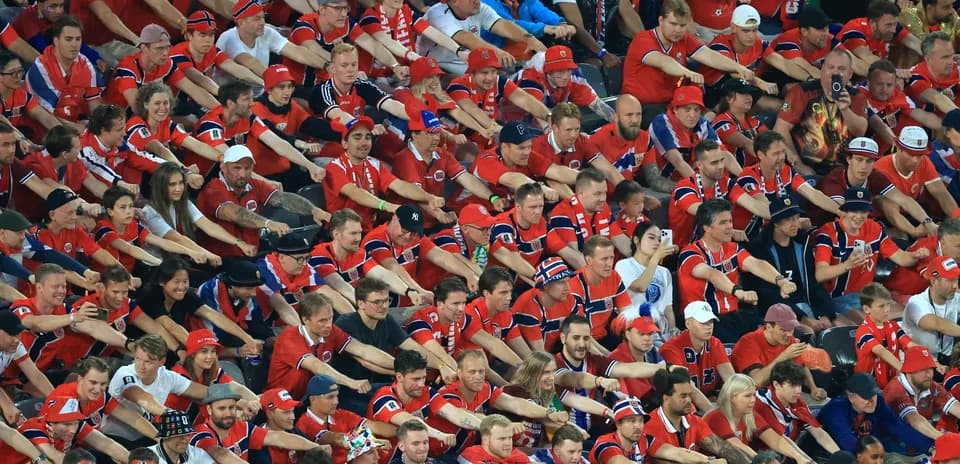 Aficionados en camiseta roja animando en el estadio