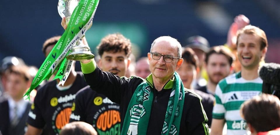 Entrenador levantando el trofeo con jugadores celebrando