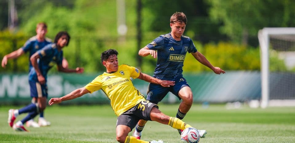Jugador de Columbus Crew II derrapando en el campo