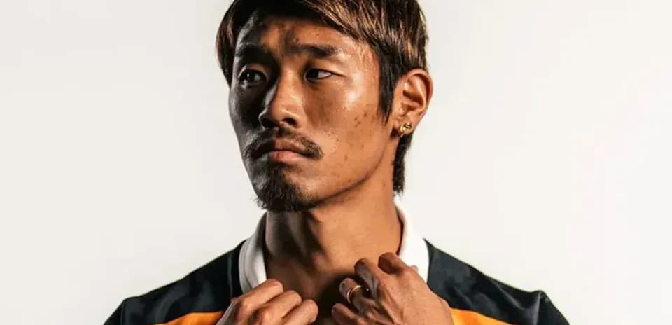 Jugador posando con camiseta de equipo y joyas
