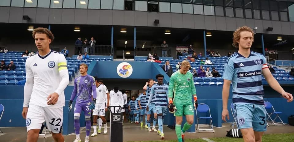 Jugadores saliendo al campo en partido de fútbol