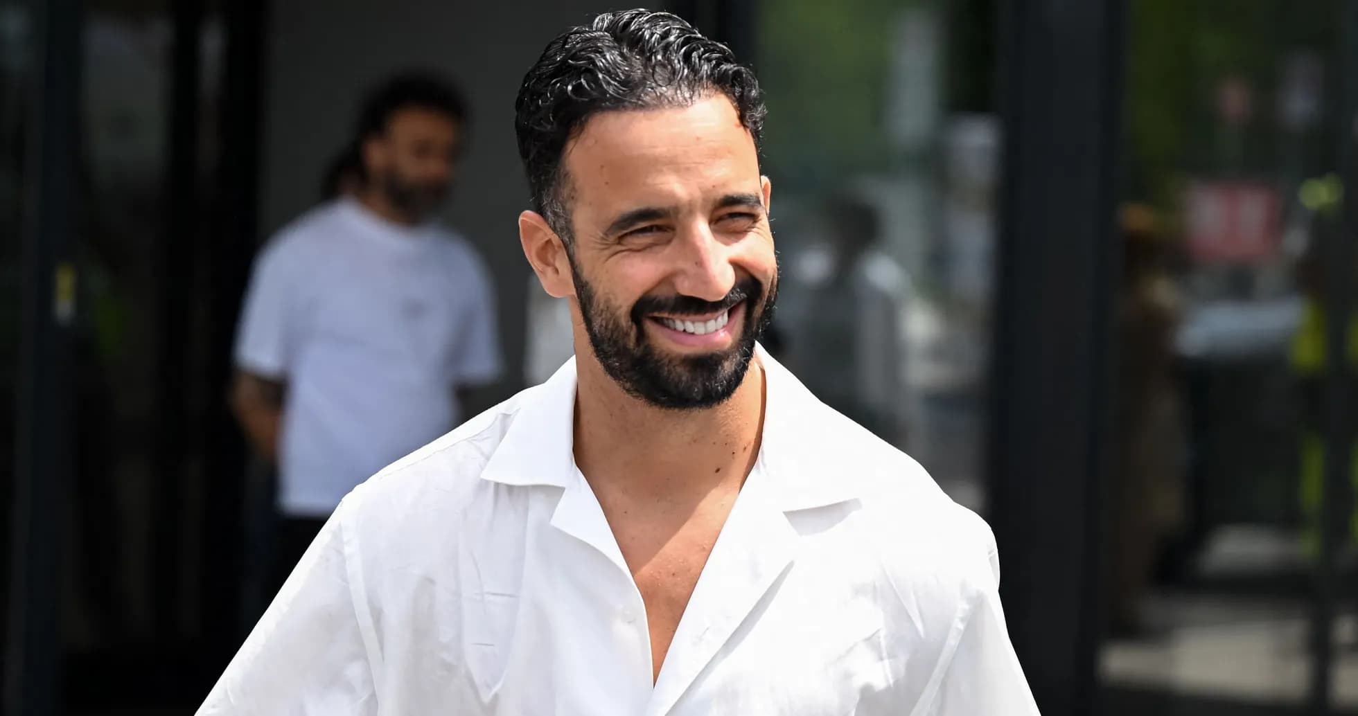 Jugador sonriendo al salir de un edificio