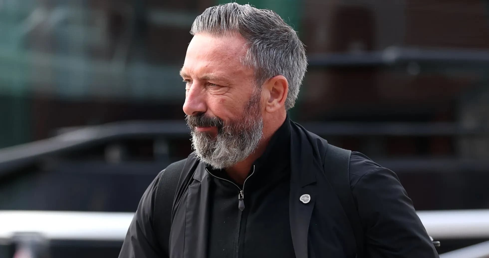 Hombre con barba gris caminando hacia la cámara