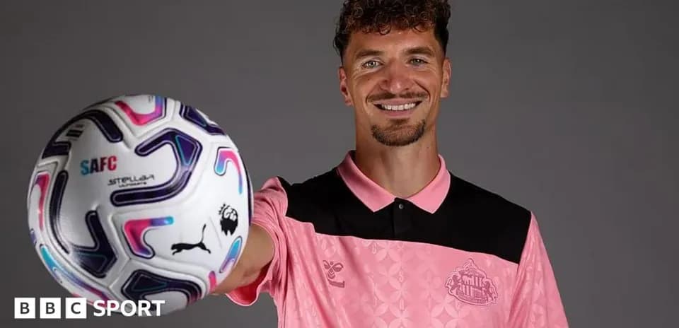 Jugador sosteniendo un balón de fútbol sonriendo