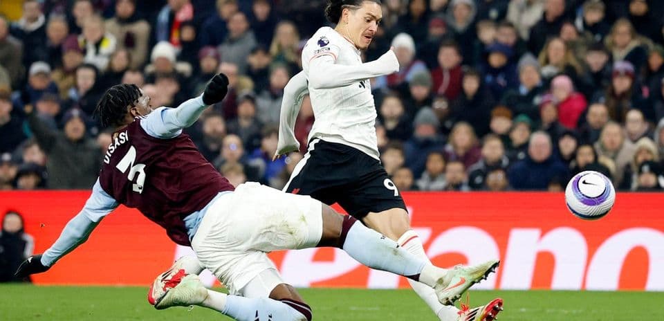 Jugador de Aston Villa cometiendo falta a jugador de Liverpool