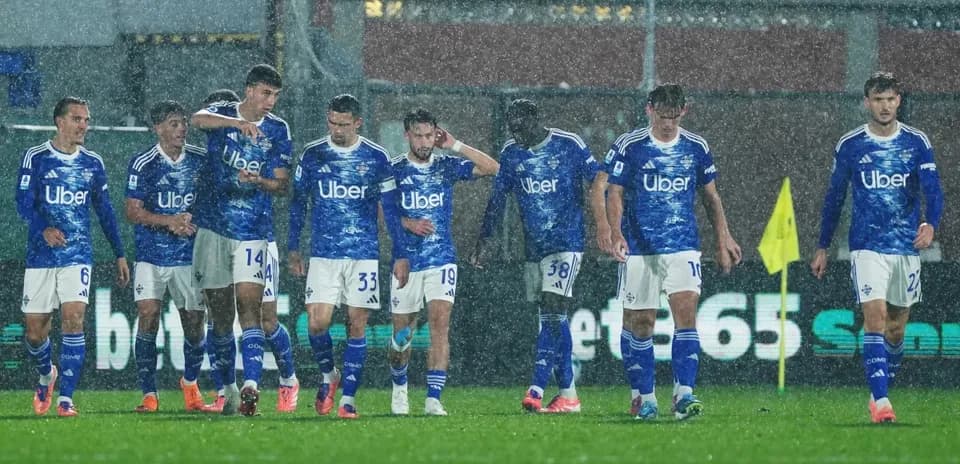 Jugadores de Como en un partido bajo la lluvia