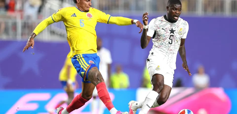 Jugador colombiano persigue a su oponente ghanés