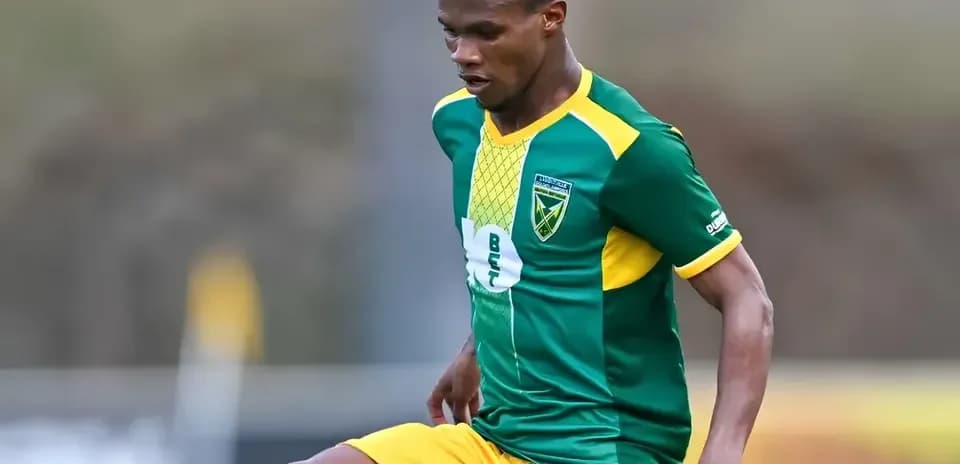 Jugador de fútbol con camiseta verde y amarilla en acción