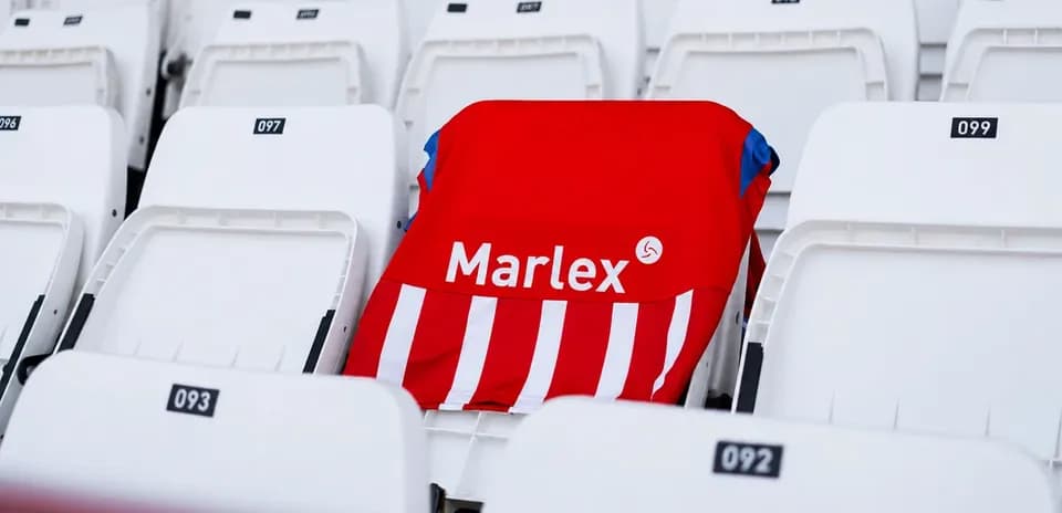 Camiseta roja con rayas en asiento vacío de estadio