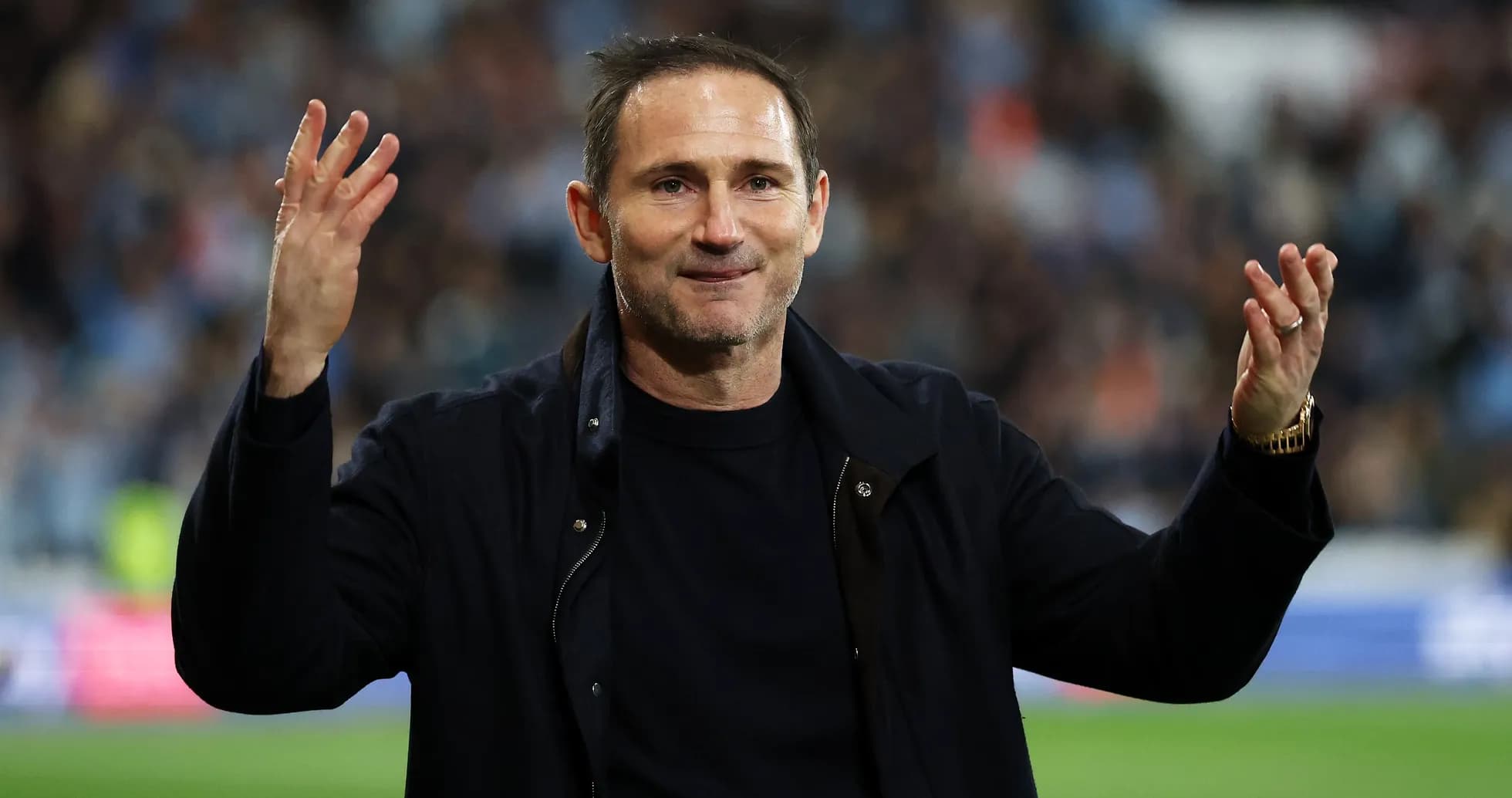 Entrenador saludando a la afición en el estadio