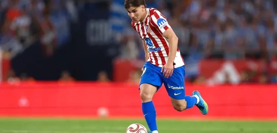 Jugador del Atlético de Madrid corriendo con el balón