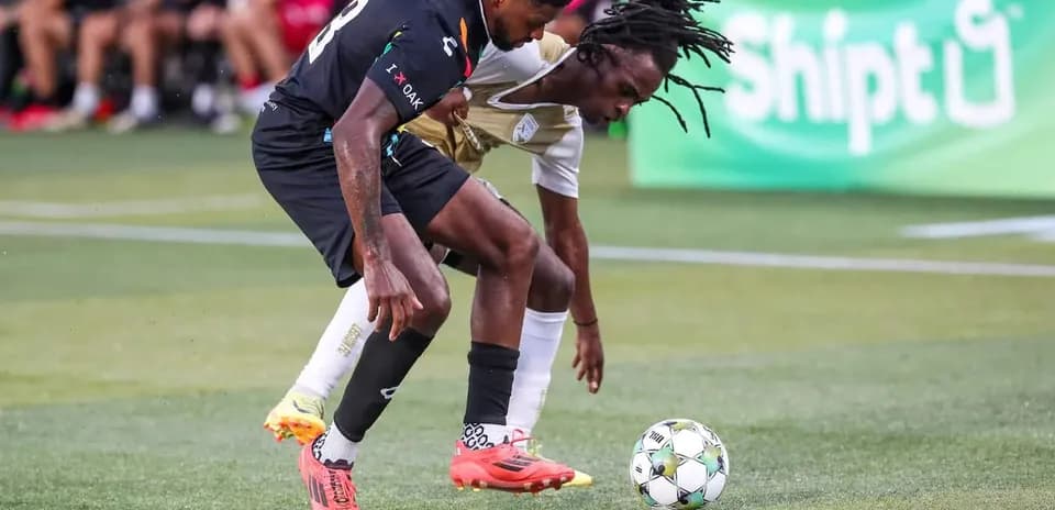 Dos jugadores luchando por el balón en el partido Dos jugadores luchando por el balón en el partido