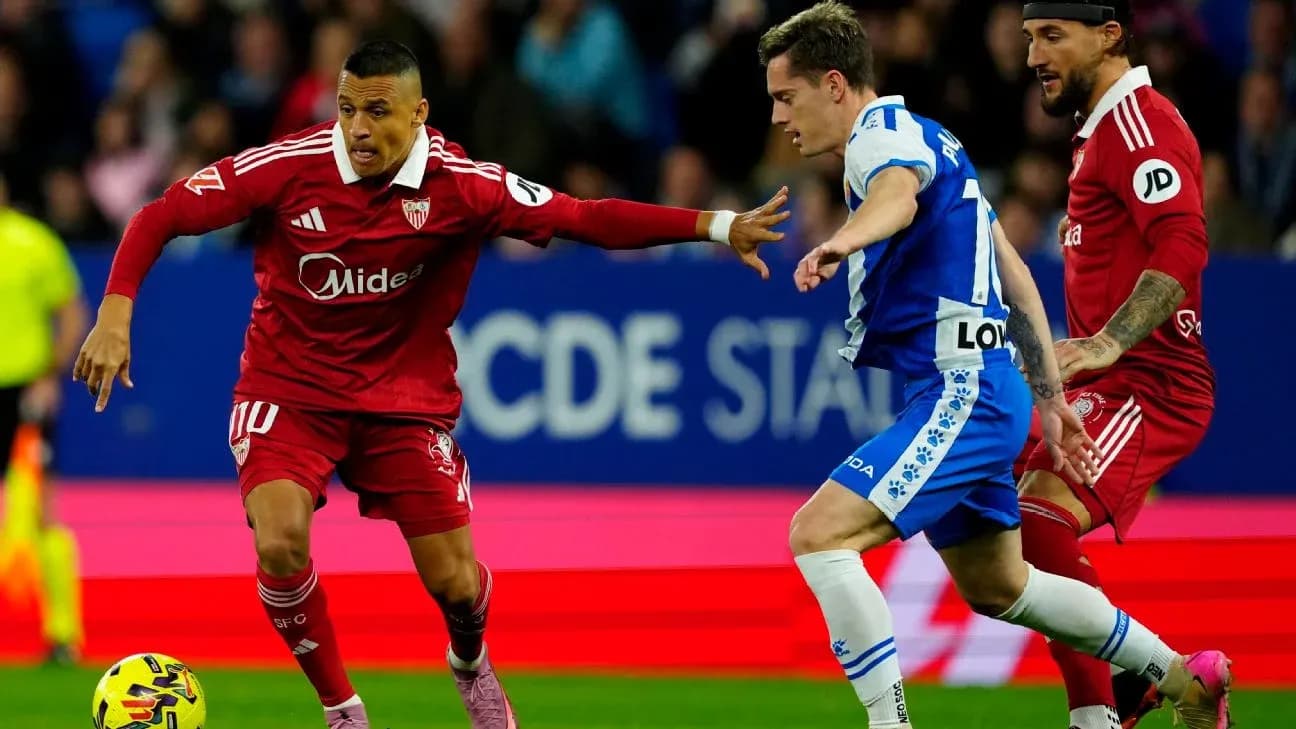 Jugador de Sevilla driblando a adversario de Espanyol Jugador de Sevilla driblando a adversario de Espanyol